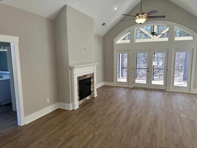 unfurnished living room with dark wood-type flooring, a fireplace, baseboards, and ceiling fan