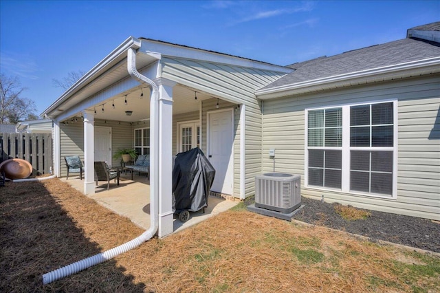 back of property with central AC unit, fence, and a patio