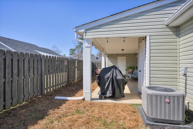 exterior space featuring a patio area, a fenced backyard, and central air condition unit