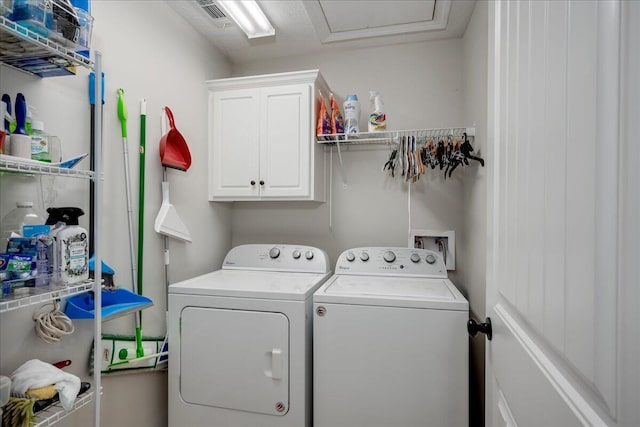 clothes washing area with visible vents, washing machine and dryer, and cabinet space