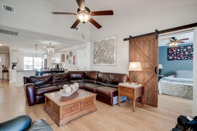 living room with ornamental molding, light wood-type flooring, and visible vents