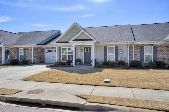 view of front of house featuring an attached garage, brick siding, concrete driveway, board and batten siding, and a front yard