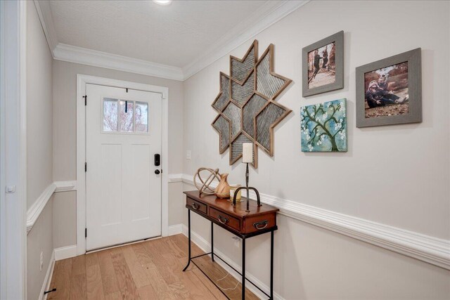 entryway featuring ornamental molding, baseboards, and light wood finished floors