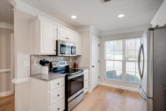 kitchen with light wood-style floors, appliances with stainless steel finishes, white cabinets, and crown molding