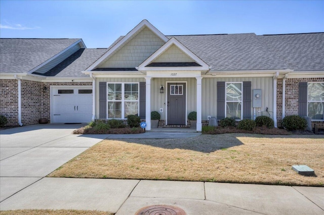 view of front facade featuring brick siding, roof with shingles, concrete driveway, a garage, and a front lawn