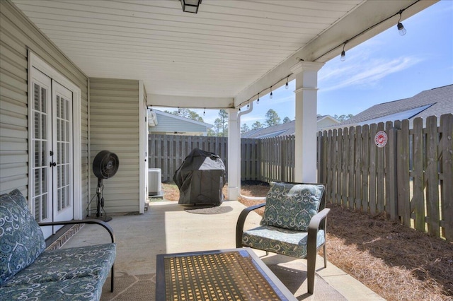 view of patio featuring french doors, outdoor dining area, and a fenced backyard