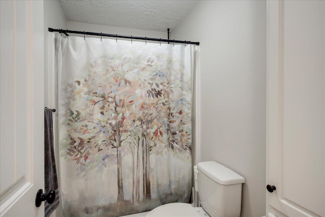 full bath with a textured ceiling, a shower with shower curtain, and toilet