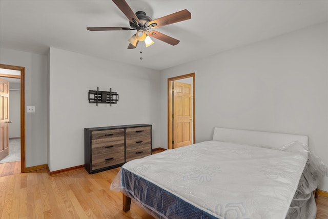 bedroom with light wood finished floors, baseboards, and ceiling fan