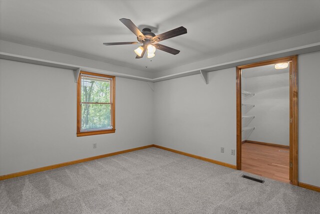 unfurnished bedroom with carpet, visible vents, baseboards, and ceiling fan