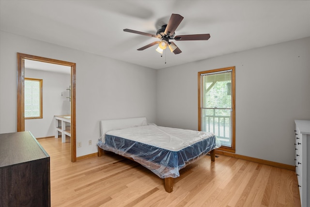 bedroom featuring light wood-style flooring, a ceiling fan, and baseboards