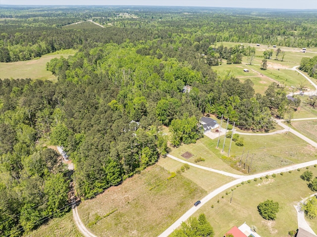 bird's eye view with a wooded view