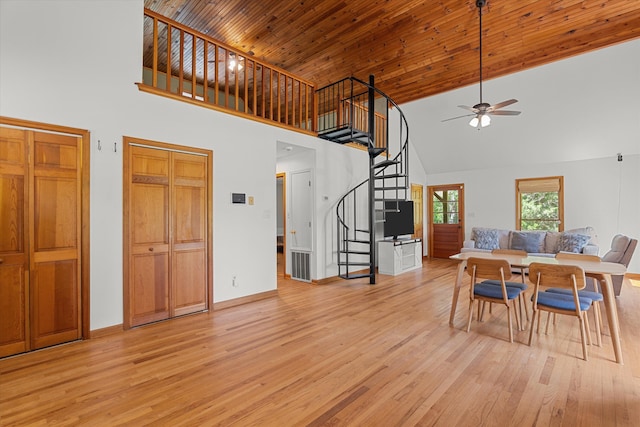 dining room with high vaulted ceiling, a ceiling fan, stairs, and light wood finished floors