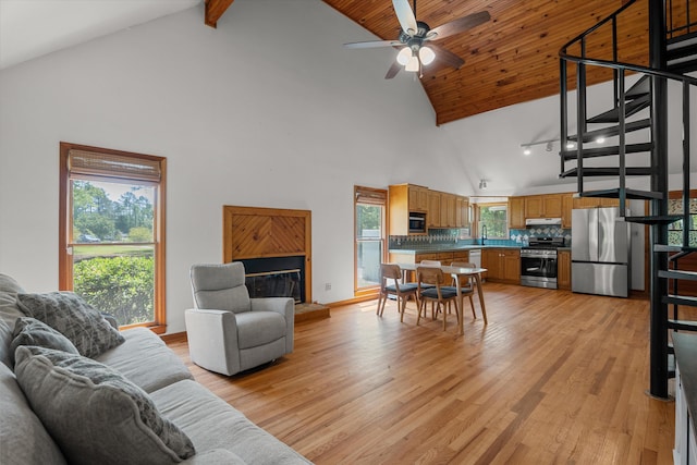 living room with light wood finished floors, beam ceiling, high vaulted ceiling, and ceiling fan