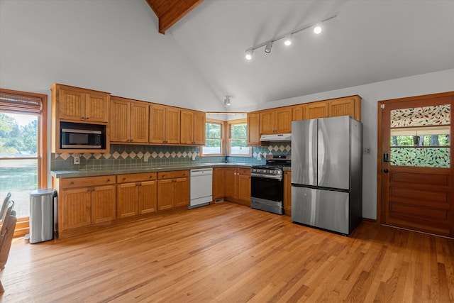 kitchen with under cabinet range hood, brown cabinets, appliances with stainless steel finishes, and light wood-style flooring