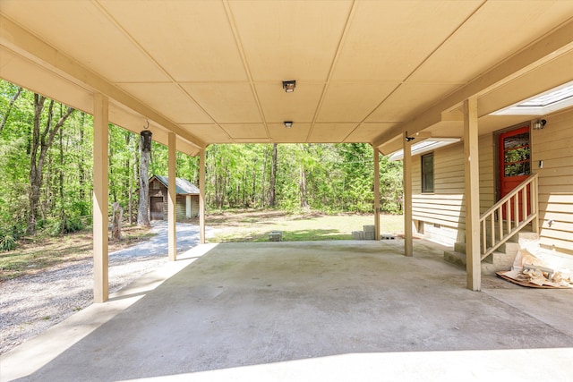 view of patio featuring entry steps, an outbuilding, a shed, and a carport