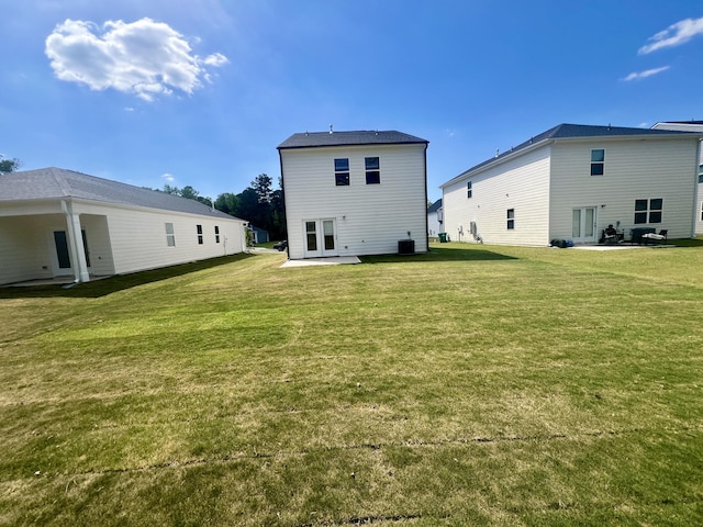 back of house with a patio and a lawn