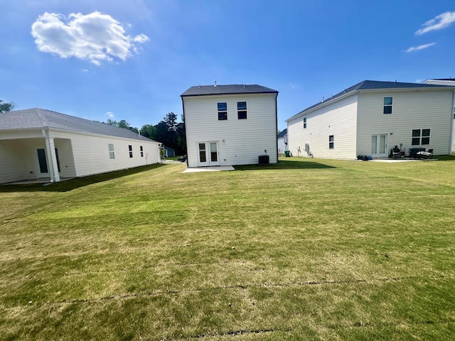 rear view of house with a patio area and a lawn