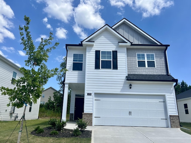 craftsman inspired home featuring an attached garage, board and batten siding, and driveway