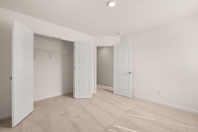 unfurnished bedroom with carpet flooring, baseboards, and a closet