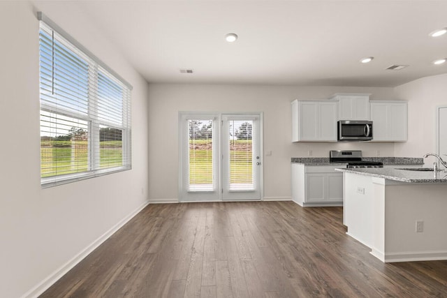 kitchen with visible vents, dark wood-type flooring, white cabinets, stainless steel appliances, and a sink