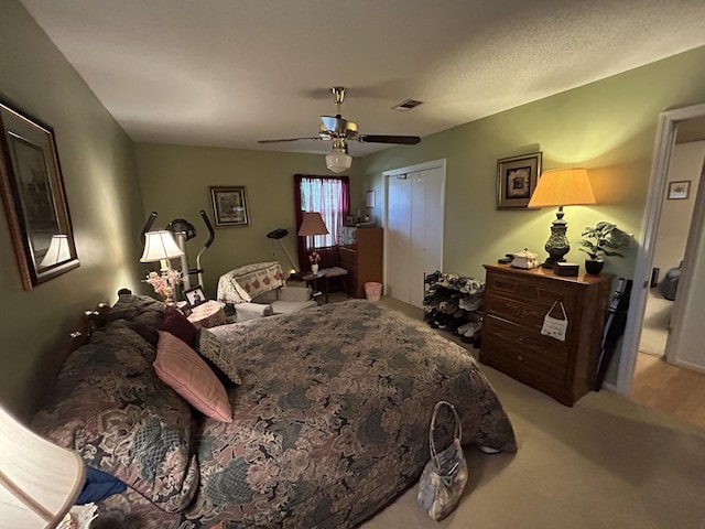 carpeted bedroom featuring a closet and ceiling fan