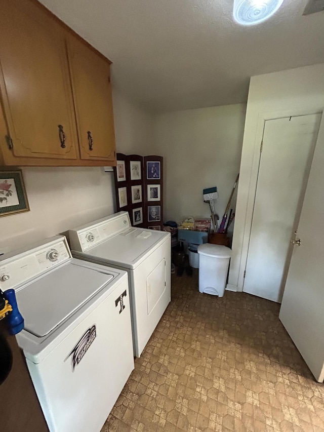 washroom with washing machine and clothes dryer and cabinet space