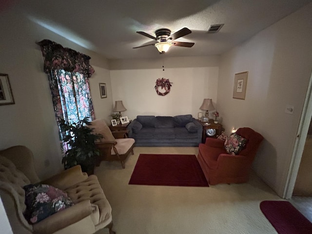 carpeted living area with ceiling fan