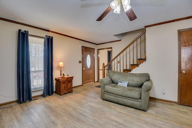 entrance foyer with ceiling fan, crown molding, and light hardwood / wood-style floors