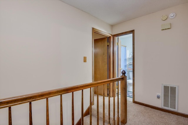 hallway with light colored carpet