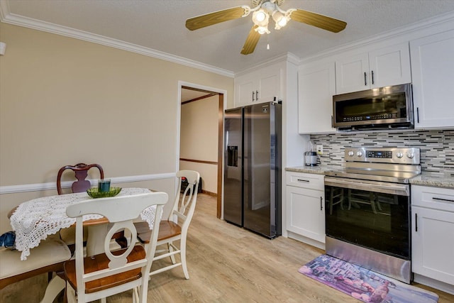 kitchen with appliances with stainless steel finishes, light hardwood / wood-style flooring, light stone counters, white cabinets, and tasteful backsplash