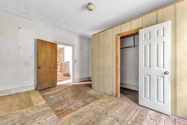 485 Adams St, Sparta, GA 31087 - unfurnished bedroom with hardwood / wood-style flooring, a closet, and wooden walls