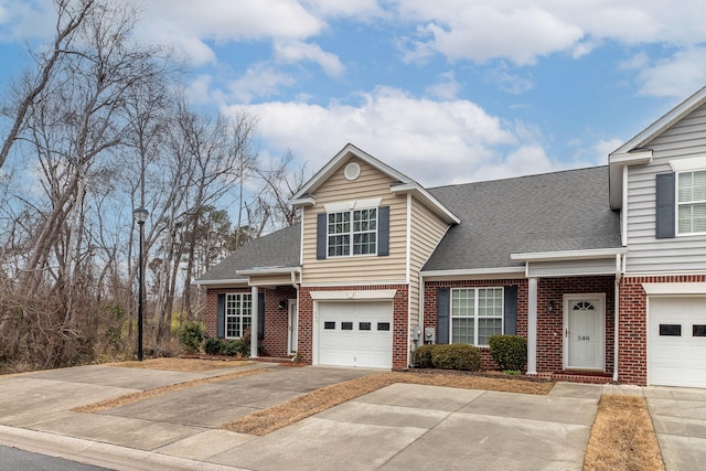 view of front of property with a garage, concrete driveway, brick siding, and roof with shingles