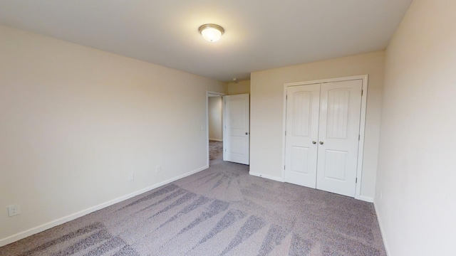 unfurnished bedroom with a closet and dark carpet