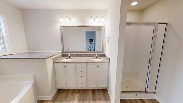 bathroom featuring hardwood / wood-style flooring, independent shower and bath, and vanity