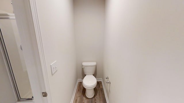 bathroom featuring toilet and wood-type flooring