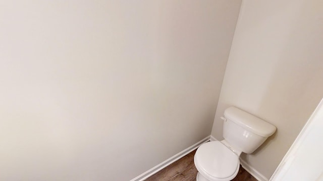 bathroom with toilet and hardwood / wood-style flooring