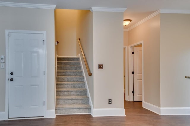 stairway with crown molding, baseboards, and wood finished floors