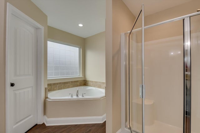 full bathroom featuring wood finished floors, a stall shower, a garden tub, and recessed lighting