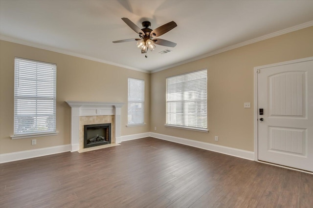 unfurnished living room featuring a healthy amount of sunlight, dark wood-style floors, and ornamental molding