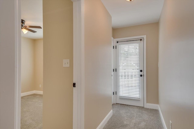 corridor featuring a wealth of natural light, baseboards, and carpet flooring