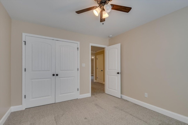 unfurnished bedroom featuring ceiling fan, a closet, carpet flooring, and baseboards