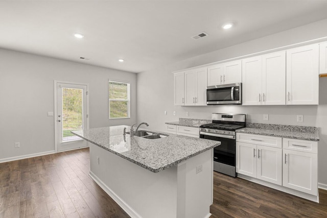 kitchen with sink, white cabinets, stainless steel appliances, and an island with sink