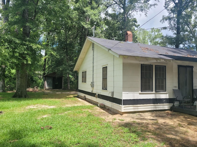 view of property exterior with a lawn and a storage shed