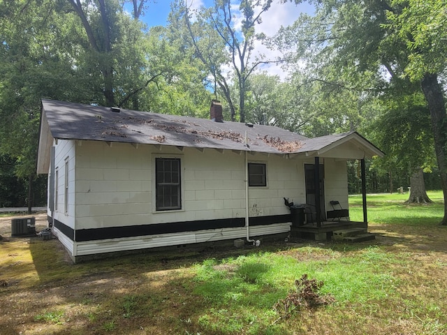 rear view of property with a lawn and central AC