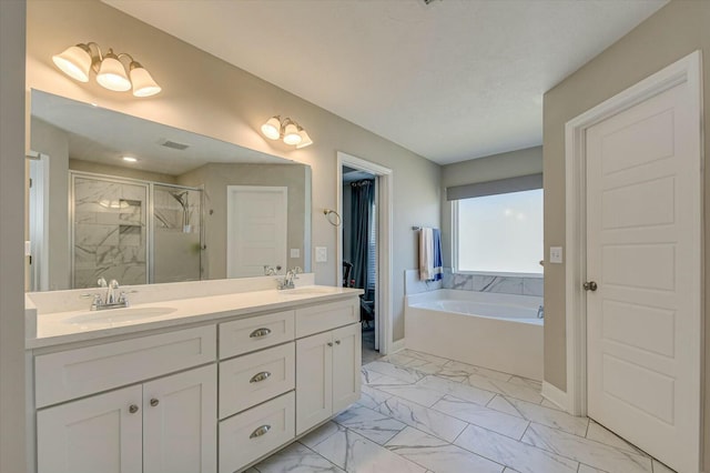 bathroom with vanity and shower with separate bathtub