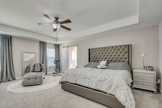 bedroom featuring carpet, ceiling fan, and a raised ceiling