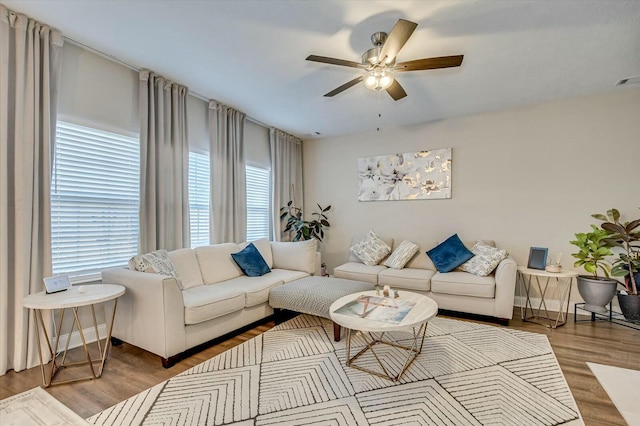 living room with ceiling fan and light hardwood / wood-style flooring