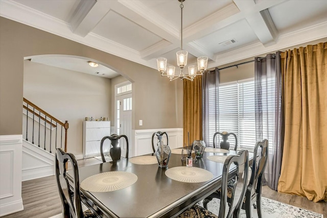 dining room featuring beam ceiling, wood-type flooring, coffered ceiling, and an inviting chandelier