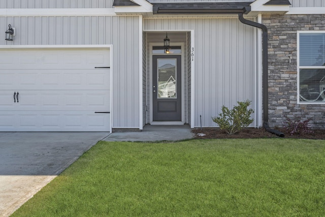 doorway to property with a lawn, an attached garage, driveway, and stone siding