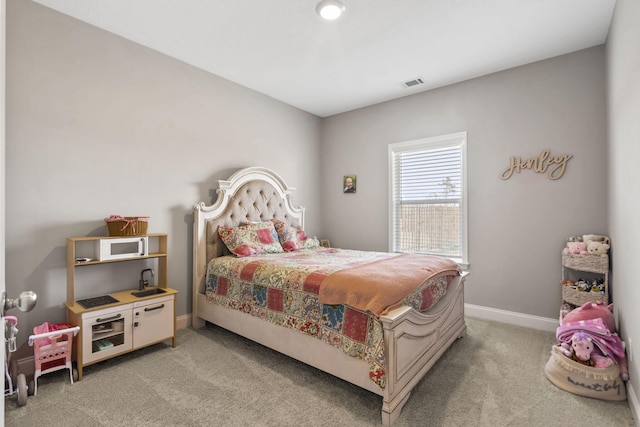 bedroom with baseboards, visible vents, and light carpet